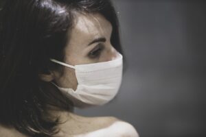 a depressed woman putting on a face mask
