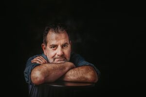 a man crossing heads and looking sad 