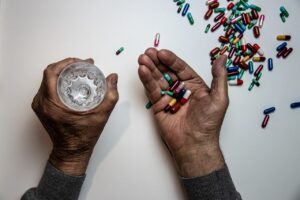 hand of a male holding a bottle of pills 
