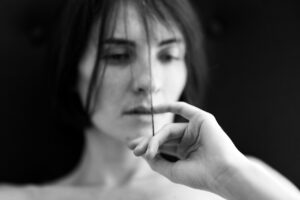 a sad and depressed woman thinking with her finger in her mouth